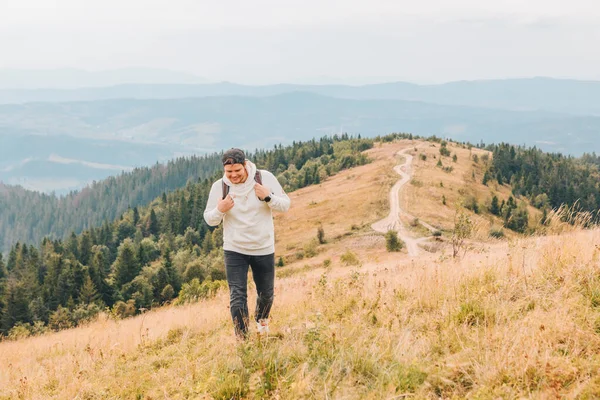 Uomo con zaino trekking dalle montagne autunnali — Foto Stock