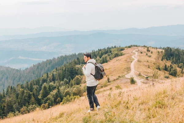 Uomo con zaino trekking dalle montagne autunnali — Foto Stock