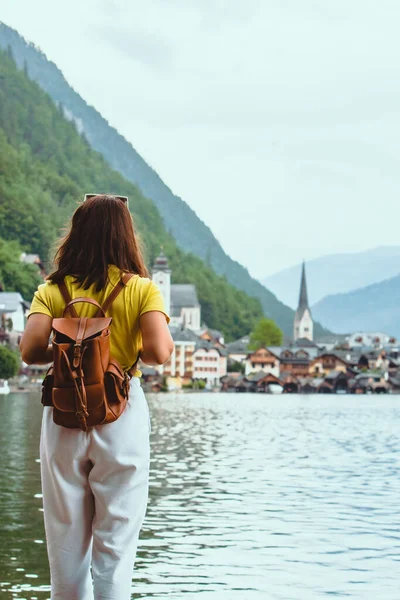 Kadın hallstatt şehir bakarak sahilde ayakta — Stok fotoğraf