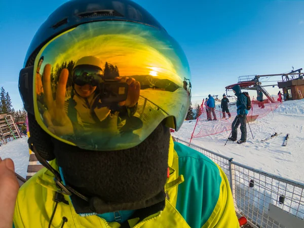 Muž v lyžařské masce zblízka. odraz. zasněžené hory při západu slunce — Stock fotografie