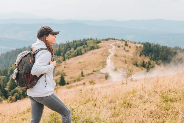 Caminhadas conceito mulher com mochila no pico das montanhas — Fotografia de Stock