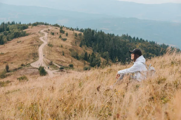 Donna seduta a terra guardando montagna escursionismo concetto — Foto Stock