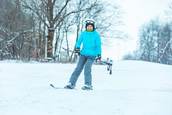 Jeune adulte souriant femme ski vers le bas par colline — Photo