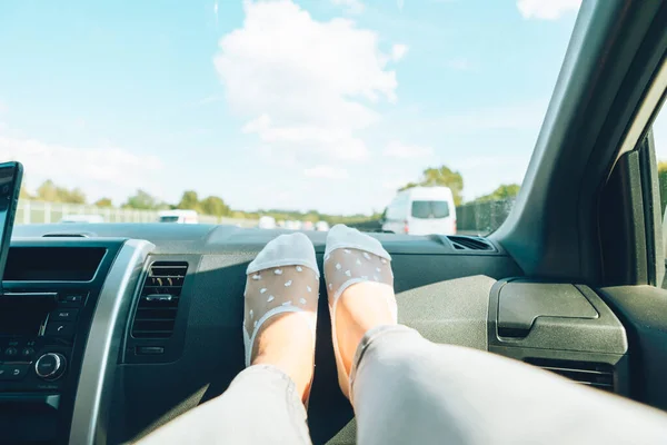 Женские ноги на автомобильной приборной панели дорожное путешествие шоссе — стоковое фото