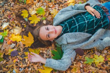 woman laying on the ground in autumn yellow leaves