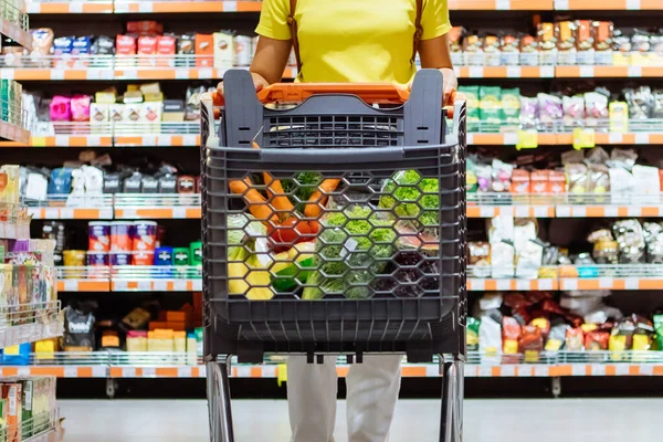 Vrouw met winkelen tussen winkel plank — Stockfoto