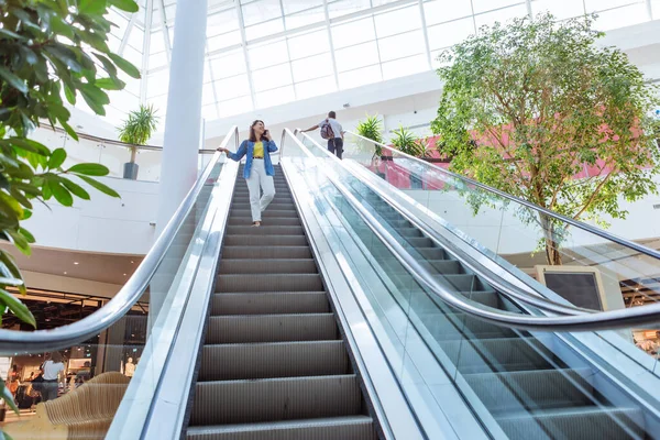 Woman in city mall walking to escalator — Stock Photo, Image