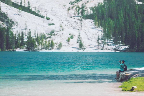 Uomo seduto alla spiaggia di montagna lago godendo la vista — Foto Stock