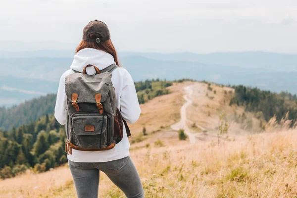Концепція пішого туризму жінка з рюкзаком на вершині гір — стокове фото