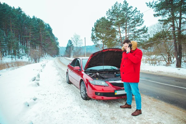 Homem de pé perto de carro quebrado na beira da estrada nevou inverno tempo — Fotografia de Stock