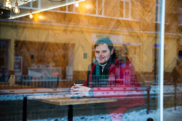 Hombre en la cafetería en abrigo rojo de invierno beber té calentamiento — Foto de Stock