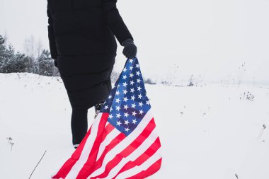 kadın yürüyüş ile filed ABD bayrağı elinde ile kar yağdı. yakın çekim