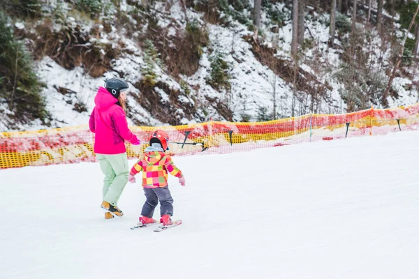 BUKOVEL, UCRÂNIA - 0 de dezembro de 2018: menino com mãe aprendendo esqui — Fotografia de Stock
