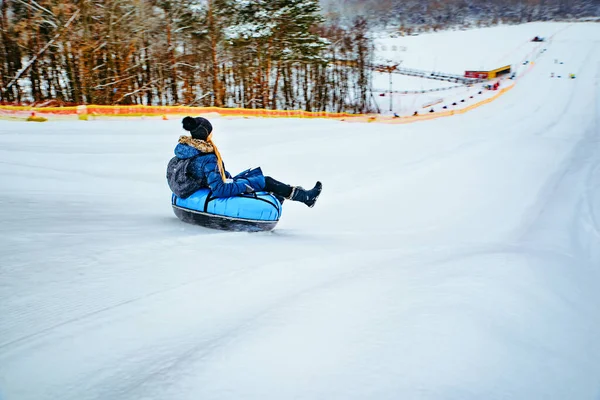 LVIV, UKRAINE - 7 janvier 2019 : une jeune femme se prépare à glisser sur une colline en tube à neige — Photo