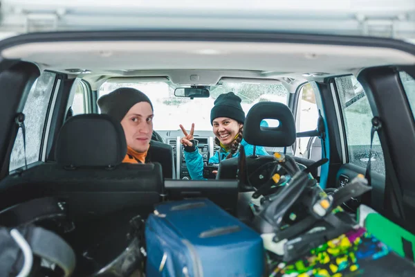 DRAGOBRAT, UCRÂNIA - 8 de dezembro de 2018: mulher sorridente sentada no carro. snowboard no porta-malas do carro. viagem rodoviária — Fotografia de Stock