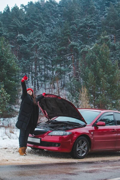 Mujer pidiendo ayuda con el coche averiado en la carretera de invierno —  Fotos de Stock