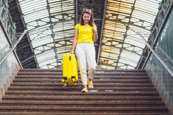 Женщина Спускается Лестнице Желтым Чемоданом Колесах — стоковое фото