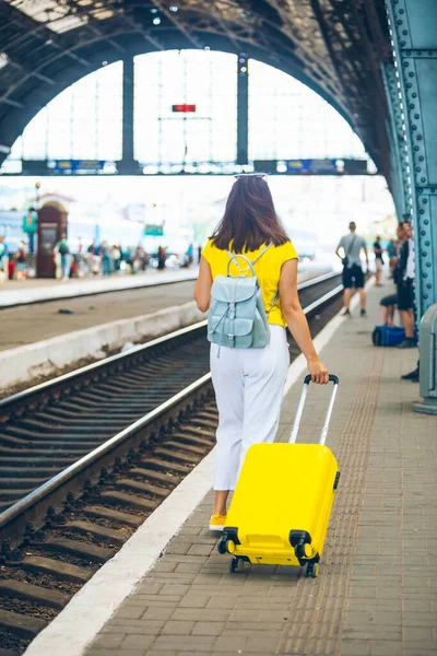woman with yellow bag at railway station copy space