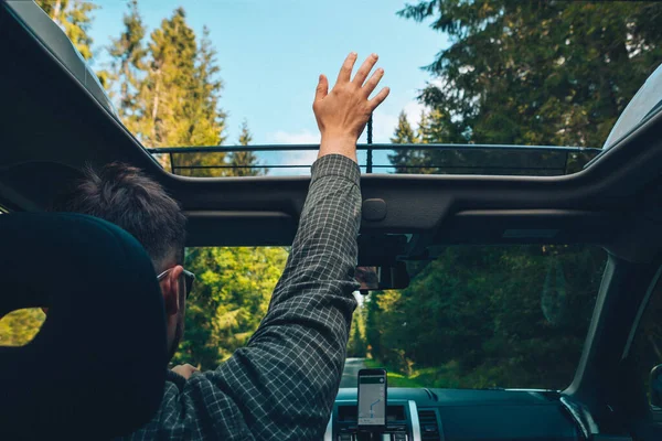 Mann Fängt Während Autofahrt Wind Mit Hand Durch Geöffnetes Schiebedach — Stockfoto