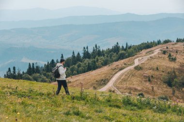 Sırt çantalı bir adam sonbahar mevsiminde dağlarda yürüyüş yapıyor.