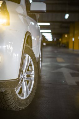 Yeraltı otoparkında beyaz bir cip. şehir yaşam tarzı. Boşluğu kopyala