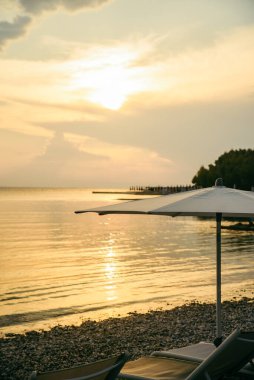 Güneş pansiyonları ve şemsiyeli deniz sahili manzarası. Boşluğu kopyala