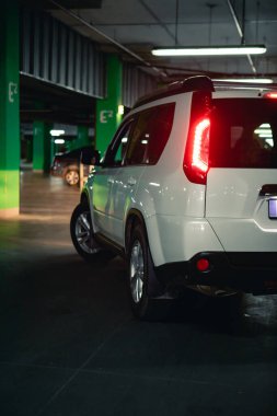 Yeraltı otoparkında beyaz bir cip. şehir yaşam tarzı. Boşluğu kopyala