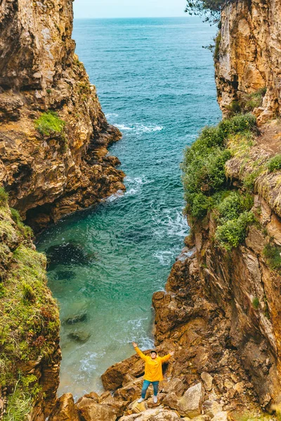 Sarı Yağmurluklu Bir Adam Kanyondaki Deniz Kıyısına Yürüyor — Stok fotoğraf