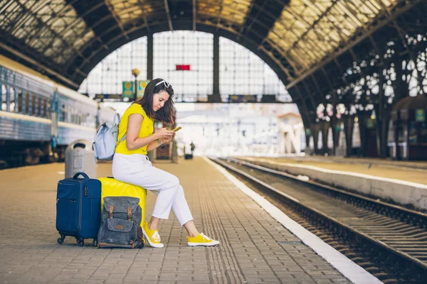 Smiling Pretty Woman Sitting Yellow Suitcase Wheels Railway Station Travel — Stock Photo, Image