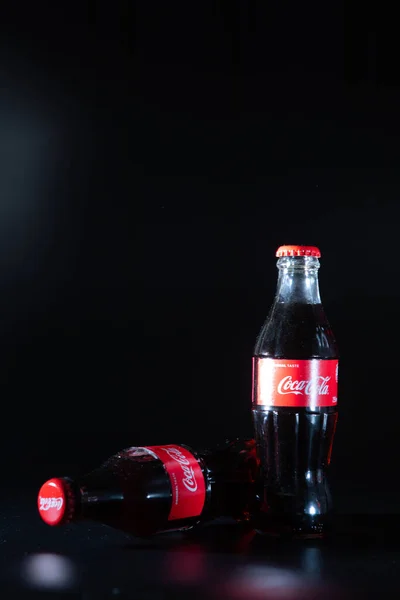 Lviv, Ukraine - May 21, 2020: two glass bottle of coca cola at black background with light — Stock Photo, Image
