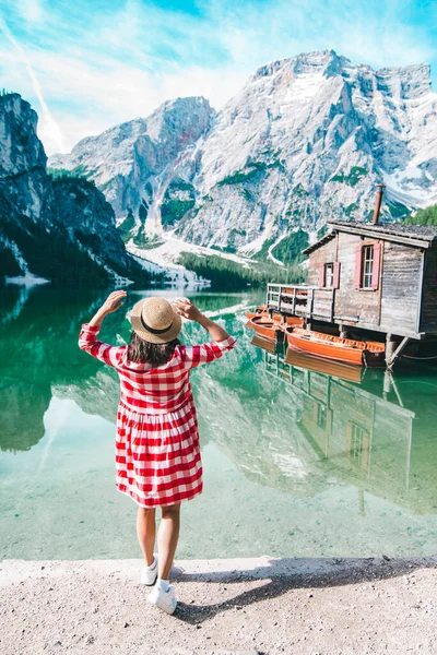 Žena v červené kostkované šaty se slaměným kloboukem při pohledu na horské jezero — Stock fotografie