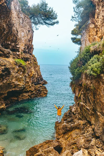 Yağmurluklu kadın Canyon 'da deniz kıyısına yürüyor. — Stok fotoğraf