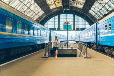 Bavullu ve sırt çantalı bir gezgin merdivenlerden yukarı çıkıyor.