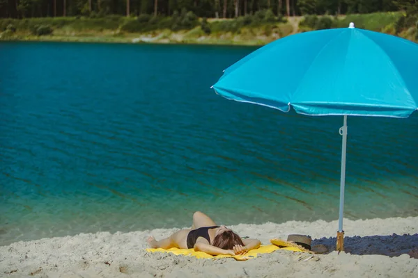 Frau Legt Sich Mit Blauem Sonnenschirm Auf Gelbe Decke Sandstrand — Stockfoto