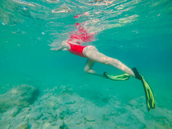 シュノーケリングマスクとフリッパーで水中の赤い水着の女性夏休み — ストック写真