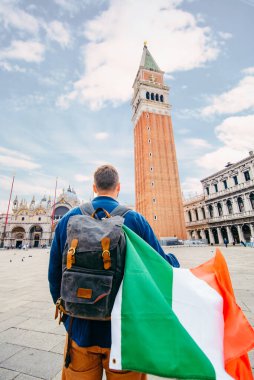 Saint Marco Square yaz tatilinde İtalyan bayrağı taşıyan bir adam.