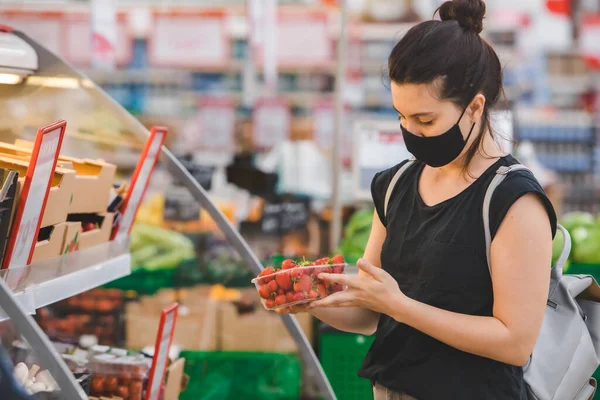 woman in medicine mask do groceries shopping. pandemic