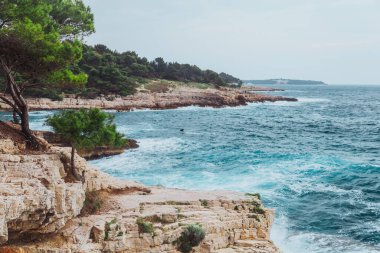 Fırtınalı deniz suyunun kayalık plajlı manzarası. Boşluğu kopyala