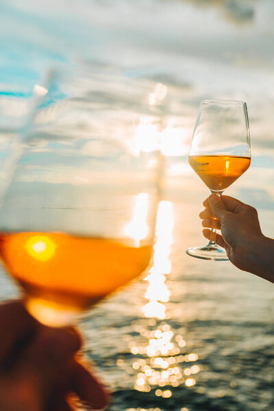 пара отдыхает на закате на морском пляже и пьет вино. летний романтический отпуск