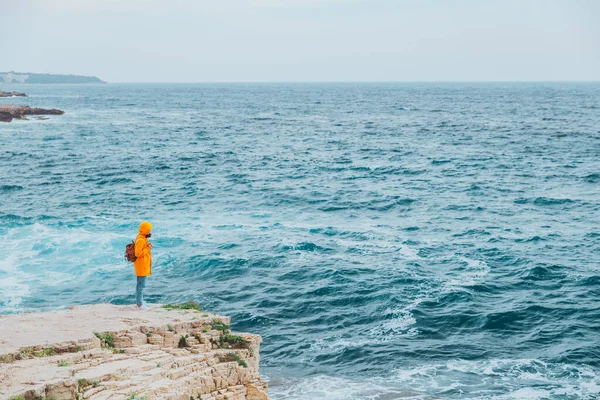 Mulher Capa Chuva Amarela Com Mochila Penhasco Olhando Para Mar — Fotografia de Stock