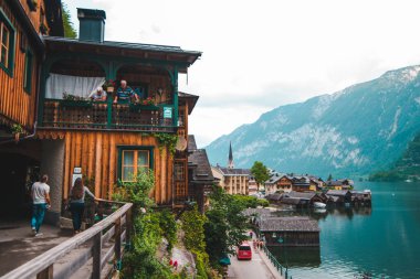 Hallstatt, Avusturya - 15 Haziran 2019: Balkondan genç çiftle konuşan yaşlı insanlar yaz mevsimini kopyalıyorlar