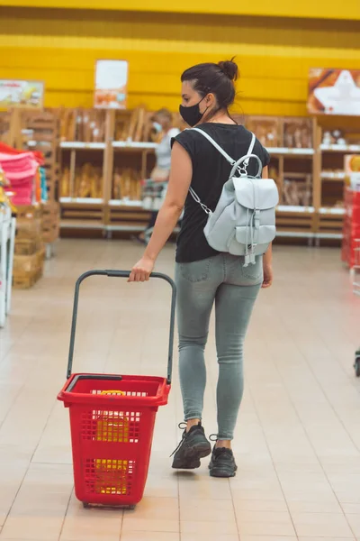 woman in medicine mask do groceries shopping. pandemic