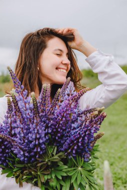 Lupin tarlasında bir kadın. Anın tadını çıkarıyorum