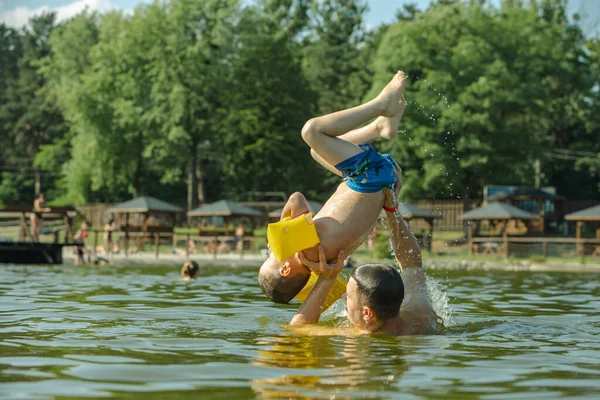 Vater Wirft Sohn Ins Wasser Und Hat Spaß Bei Sommerlichen — Stockfoto