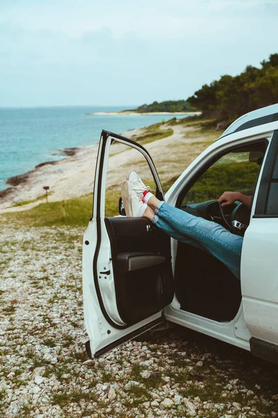 Πόδια Των Ανδρών Προεξέχουν Από Αυτοκίνητο Σταθμευμένο Στη Θάλασσα Παραλία — Φωτογραφία Αρχείου