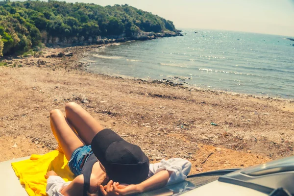 快乐的女人在海上夏季海滩坐在汽车引擎盖度假的概念 — 图库照片