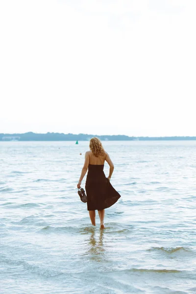 Mulher Vestido Preto Andando Água Praia Mar Despreocupado — Fotografia de Stock
