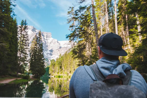 hiker man walking by path around mountain lake. summer leisure activities. vacation concept. copy space