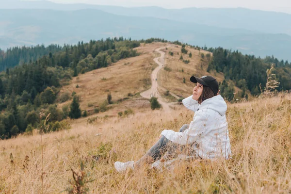 Donna seduta a terra guardando montagna escursionismo concetto — Foto Stock