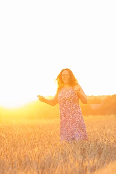 Hermosa mujer madura en vestido de sol en el campo de trigo en la puesta del sol — Foto de Stock